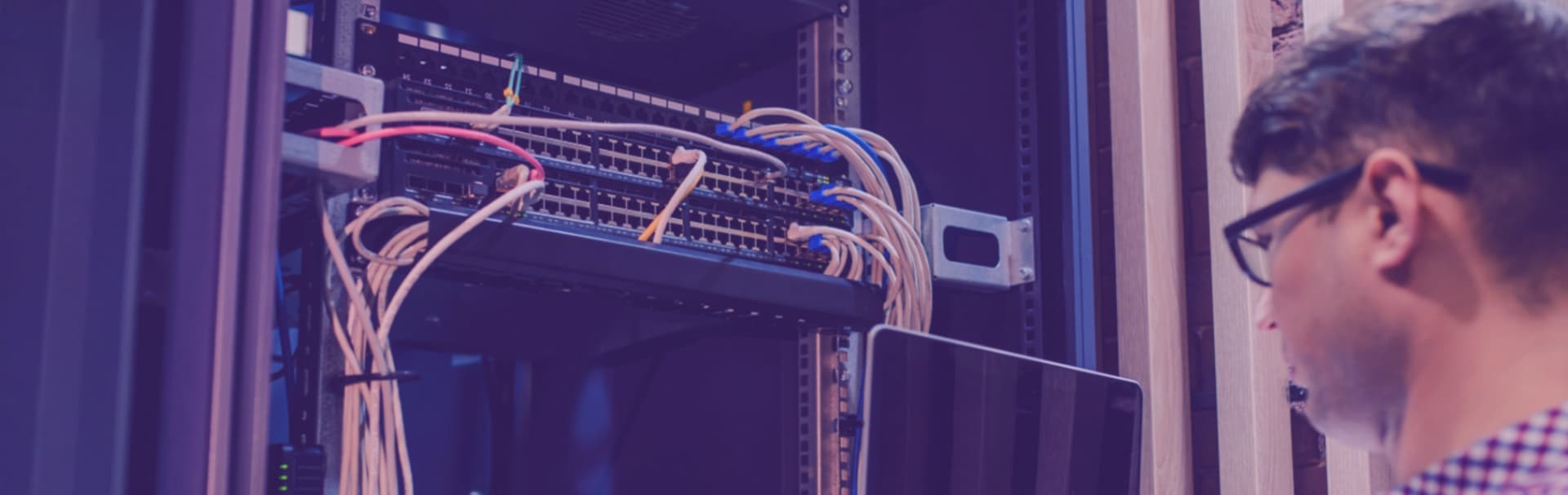 Technician working on a structured cabling rack during a home network installation