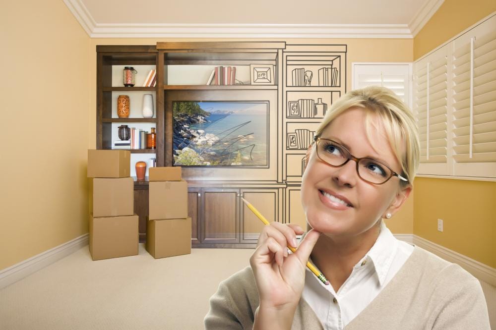 female holding pencil in room with drawing of entertainment unit